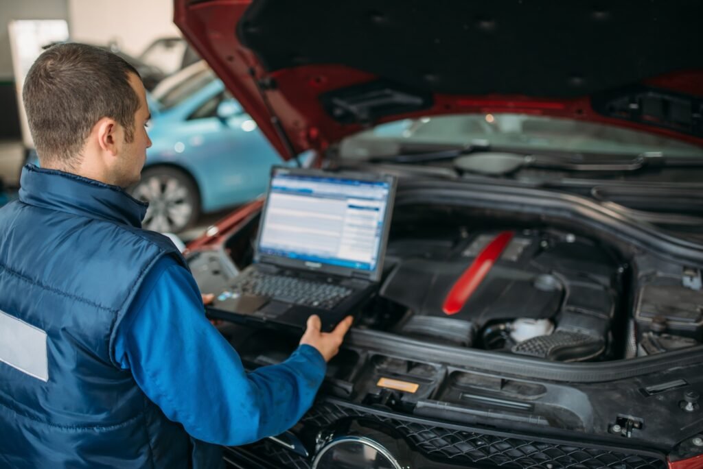 engineer makes computer diagnostics of car engine